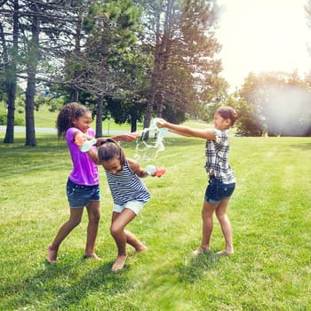 Having fun with water. adorable little girls playing with water balloons outdoors