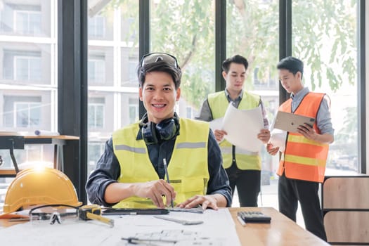 Civil engineer teams meeting working together wear worker helmets hardhat on construction site in modern city. Foreman industry project manager engineer teamwork. Asian industry professional team