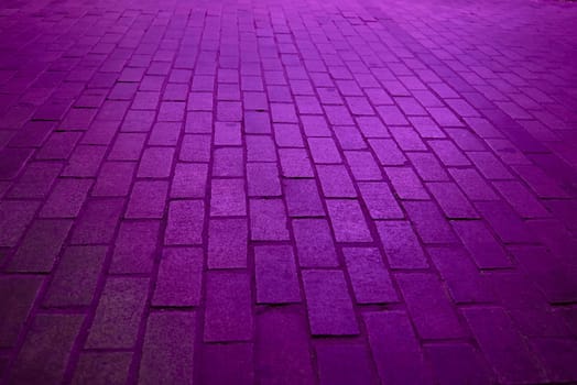 Background. Rectangular cobblestone street with purple light.No one, parallel, perpendicular, perspective depth