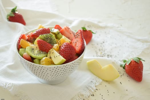 Bowl of fresh fruit salad, kiwi, apples, oranges.