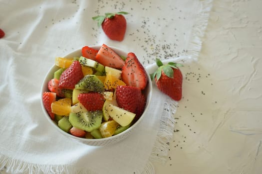 Bowl of fresh fruit salad, kiwi, apples, oranges.