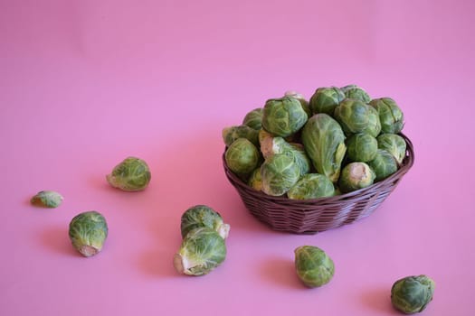 Fresh and tasty Brussels sprouts on a pink background.