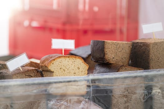 Buy bread at the store. Black and white bread on the bakery counter. Buying fresh bread, seeded black rye and hemp seeds