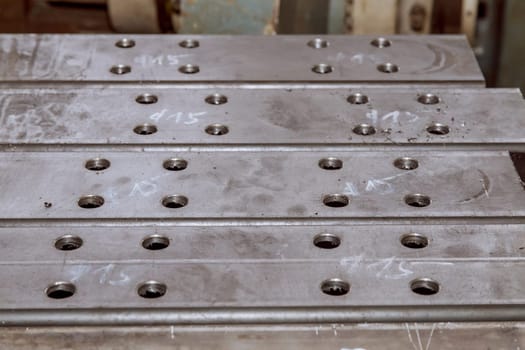 Drilled holes in metal posts for attaching various parts to the posts. Metal shavings near the holes.