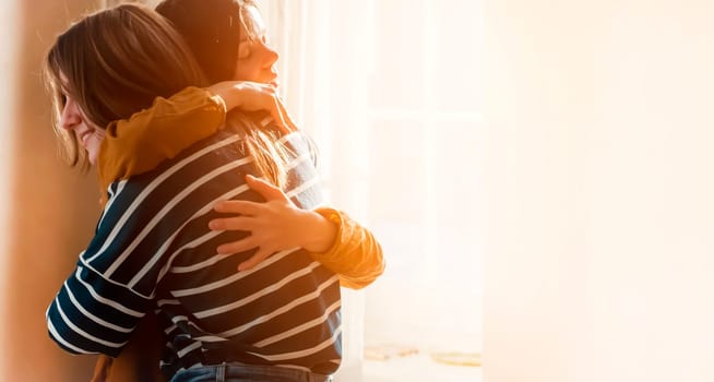 Two female friends of different ethnicity are embracing in the sun and happy to meet each other. Girls celebrate the holidays and hug tightly and warm, feel an emotional connection and love.