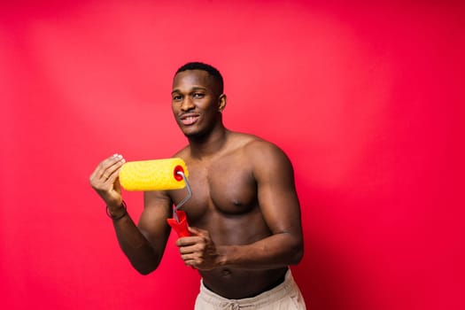 African-American painter on a red studio background topless