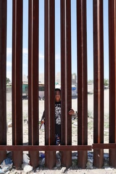 School kid on the US to Mexico border fence or wall in Sunland Park, New Mexico enjoying themselves. Kids stopped at the border.