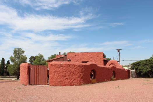 Red Sante Fe Design Adobe House with blue cloudy background.