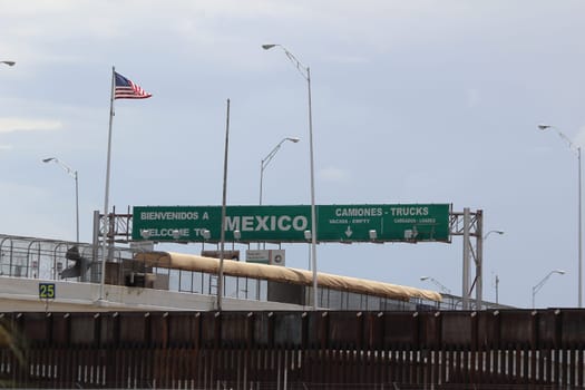 Border of Mexico and the United States, with flags and walking bridge connecting El Paso Texas to Juarez, Mexico