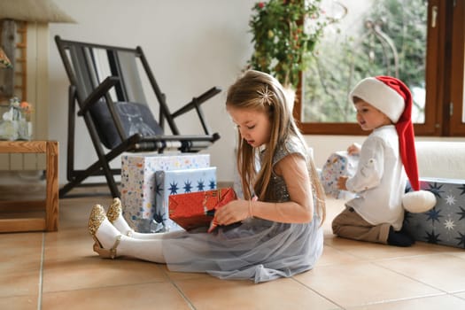 Brother and sister unwrapping christmas presents