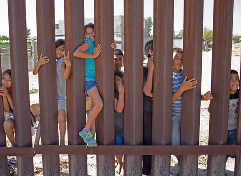 School kids on the US to Mexico border fence or wall in Sunland Park, New Mexico enjoying themselves. Kids stopped at the border.