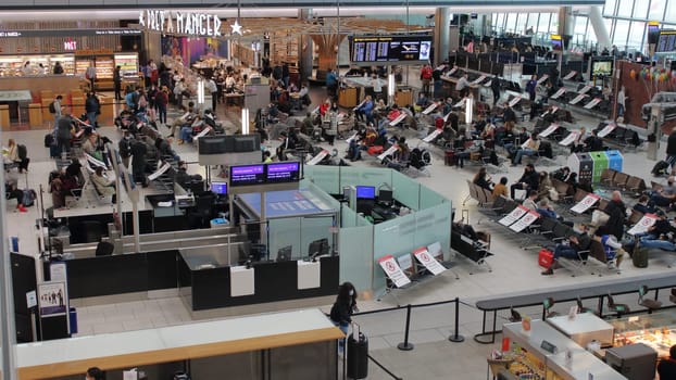 London, UK - December 2020: Terminal showing social distancing signs at Heathrow Airport. People waiting to fly or not.