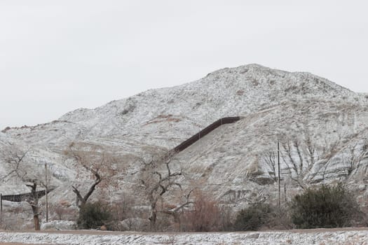 Border wall covered in snow in the mountains in El Paso.