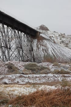 Old fashioned metal railway bridges leading to snowy mountains in El Paso, Texas.