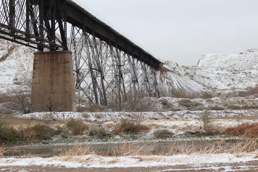 Old fashioned metal railway bridges leading to snowy mountains in El Paso, Texas.