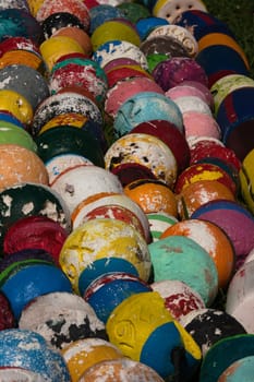 Two old fishing net metal balls on wooden floor