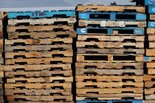 cargo and shipping concept : Stack of colorful rough wooden pallets background at warehouse.