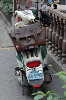 Lima, Peru - November 18, 2018: Vintage triumph Motorcycle, carying a leather bag. Parked close to fence.