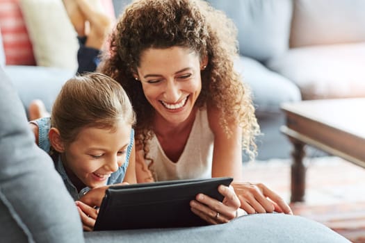 Technology connects them. a mother and her little daughter using a digital tablet together at home