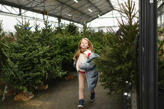 A girl running in a farm of Christmas trees