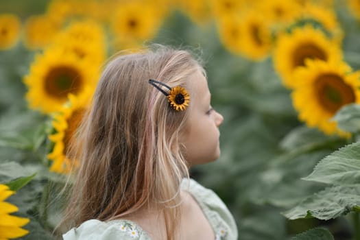 A girl in a dress enjoys life in a field with sunflowers