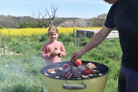 Extended family cooking barbecue in park