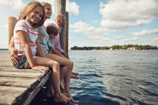 Family outings are her favourite. a young family on a pier while out by the lake