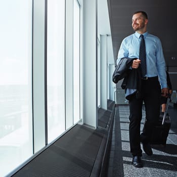 Travel is his occupational perk. an executive businessman walking through an airport during a business trip