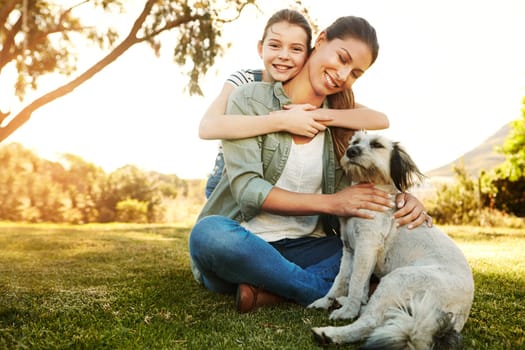 Their weekends arent complete without a visit to the park. a mother and her daughter playing with their dog at the park