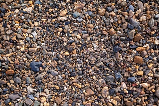 Crushed stone on the seashore. Selective focus on object. The stones were laid on the ground in the garden as a background. Background blur. Pebble stones background.