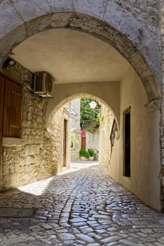 Narrow street with stone houses. Old houses and old narrow alley in Trogir, Croatia, Europe. Streets in old town.