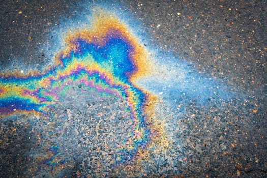 Gasoline oil spill on the pavement as a texture or background. Environmental pollution concept