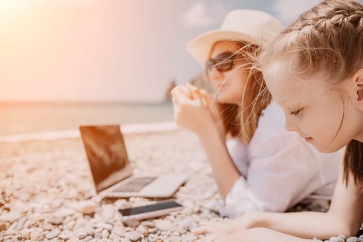 Woman sea laptop. Business woman in yellow hat working on laptop by sea. Close up on hands of pretty lady typing on computer outdoors summer day. Freelance, digital nomad, travel and holidays concept.