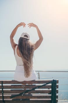 Woman travel sea. Young Happy woman in a long red dress posing on a beach near the sea on background of volcanic rocks, like in Iceland, sharing travel adventure journey