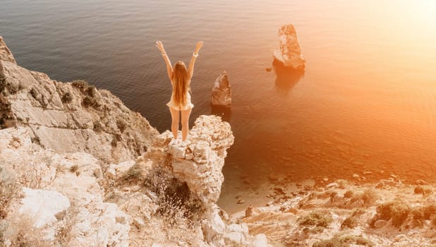 Woman travel sea. Happy tourist taking picture outdoors for memories. Woman traveler looks at the edge of the cliff on the sea bay of mountains, sharing travel adventure journey.