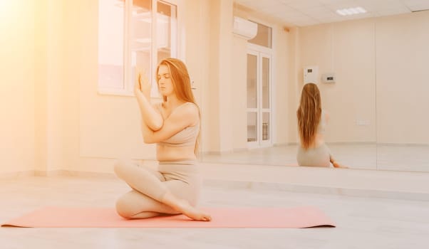 Group of young womans fitness instructor in Sportswear Leggings and Tops, stretching in the gym before pilates, on a yoga mat near the large window on a sunny day, female fitness yoga routine concept.