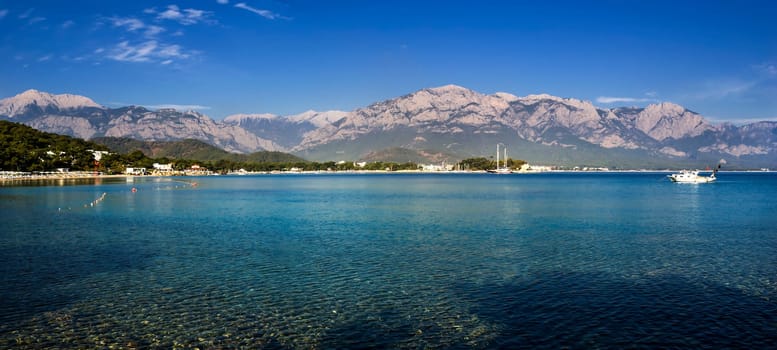 Kemer Antalia nice view of the sea. Beach Kemer Antalia with sand and mountains, the sea with the ship. Beautiful harbor near the sandy beach.