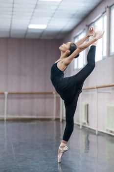 Asian woman dancing in ballet class doing bilman pose