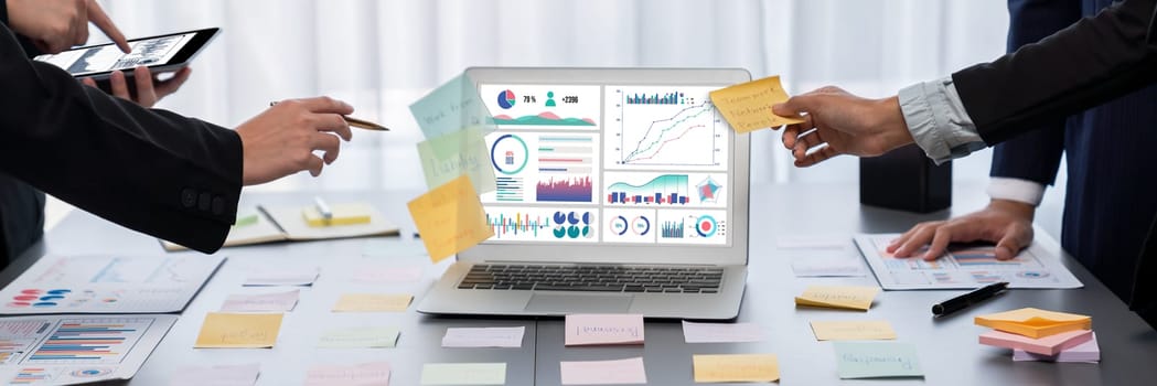 Analyst team use sticky note for creative and analytic brainstorm for business idea with BI data dashboard on laptop screen. Analysis financial data visualization tech for marketing strategy. Prodigy