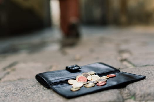 Photo of the sidewalk and legs of man who lost a black leather wallet while walking