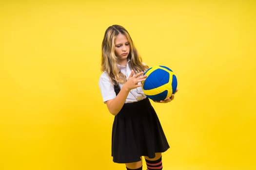 Portrait of cute eight year old girl in volleyball outfit isolated on a red yellow background