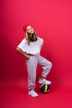 Portrait of cute eight year old girl in volleyball outfit isolated on a red yellow background