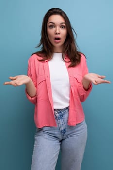 confused brunette woman with hair below her shoulders in a shirt shrugs her shoulders.