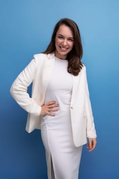 close-up portrait of caucasian brunette with long hair woman in white dress and jacket posing on studio background.