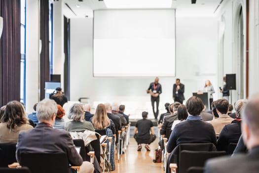 Business team leader receiving award prize at best business project competition event. Business and entrepreneurship award ceremony theme. Focus on unrecognizable people in audience