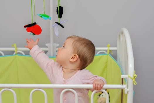 The child touches mobile hanging felt toys