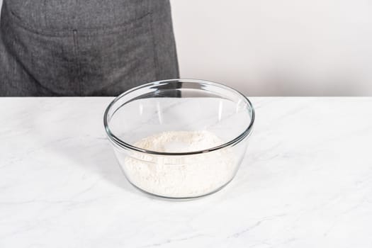 Mixing ingredients in a glass mixing bowl to bake patriotic cinnamon twists.