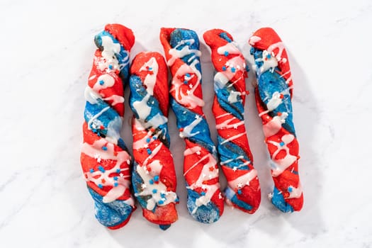 Patriotic cinnamon twists drizzled with a white glaze and decorated with star sprinkles.