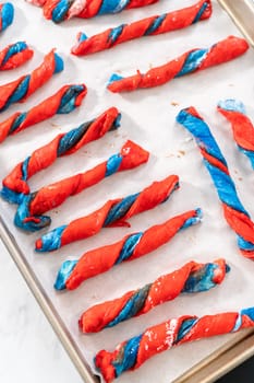 Rising patriotic cinnamon twists on the baking sheet lined with parchment paper.