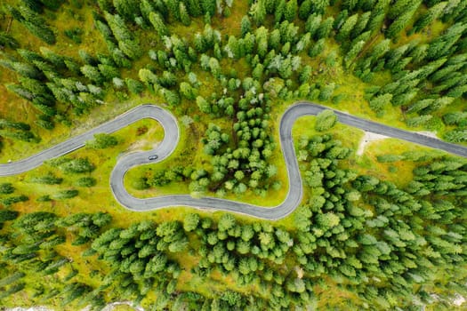 Famous Snake Road surrounded by forests and autumn meadows of Giau Pass. Sightseeing driveway serpentine for cars of Alpine mountains